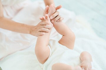赤ちゃんの足を支えるお母さんの手