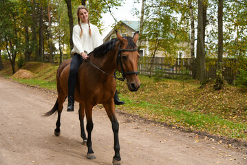 Young girl walking with a horse in nature