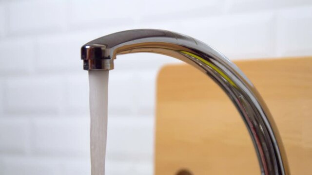 Close-up of water running from kitchen sink faucet