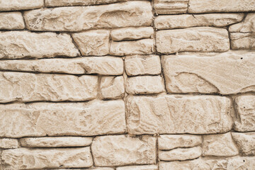 Textured background with brick particles. A wall of pieces of materials. Wall with cracks and seams.