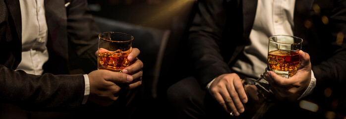 Closeup businessmen holding a glass of whiskey - Powered by Adobe