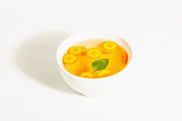 Transparent chicken broth with vegetables in ceramic bowls
