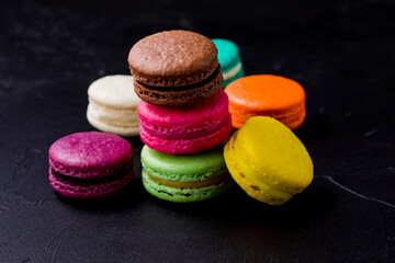 Colorful macarons cookies on the black background
