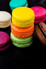 Colorful macarons cookies on the black background