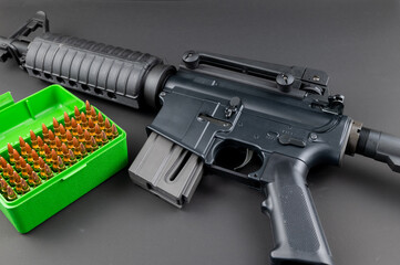 AR-15 style assault rifle with a box of 5.56mm ammunition