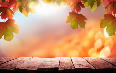 Naklejka na ściany i meble A wood table, tabletop product display with a golden autumn sunset sky and leaves background for seasonal, autumnal thanksgiving images.