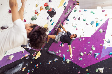 Handsome athletic men climbing on a indoor climbing wall. Extreme sports concept.