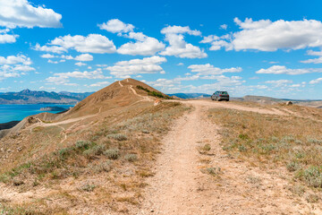 Beautiful landscape of mountainous terrain with hills against a blue sky with clouds