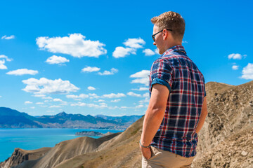 A young man in the mountains with views of the hills