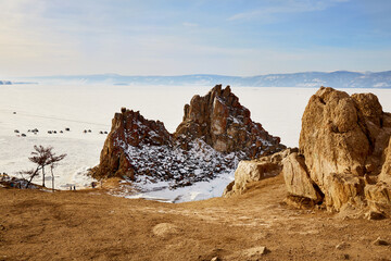 Fototapeta na wymiar Beautiful view of Cape Burhan or Shamanka rock on Olkhon island in winter. Frozen Lake Baikal, snow on the surface of the ice. 