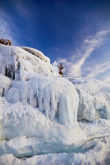 Icy rocks and icicles of Olkhon Island. Frozen Lake Baikal. Winter fairy tale. Natural background.Vertical orientation.