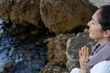 A beautiful young woman is practicing meditation in the nature