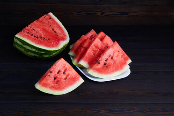 Fresh ripe sliced watermelon on dark wooden background. 