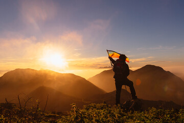 hiker with backpack and trekking poles waving an lgbt pride flag demanding the inclusion and respect of gay people in sport.