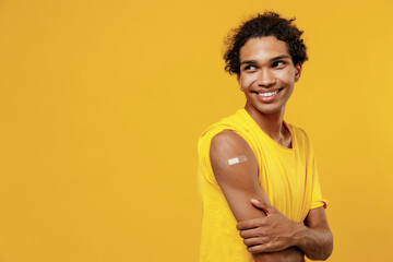 Young fun african american man with adhesive plaster after covid-19 coronavirus vaccine injection...