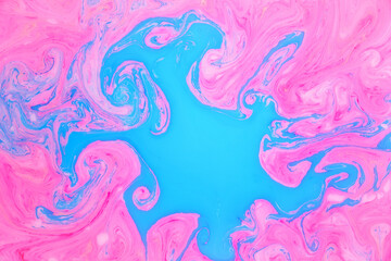 Abstract colored marble background, stains of pink and blue paint on the surface of the water. Liquid colorful backdrop.
