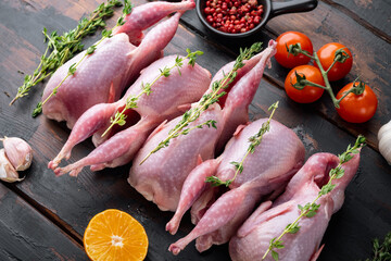 Fresh  raw meat quails ready for cooking, on dark wooden background