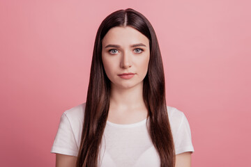 Fototapeta premium Photo of serious attractive young woman wear white t-shirt isolated on shine pastel pink color background