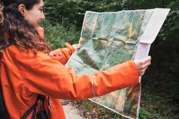 Adventurous Girl navigating in with a Topographic Map in Irati forest. Adventure concept.