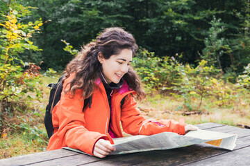 Adventurous Girl navigating in with a Topographic Map in the woods. Adventure concept.