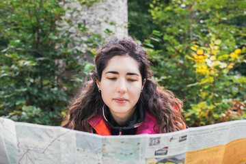 Adventurous Girl navigating in with a Topographic Map in the woods. Adventure concept.
