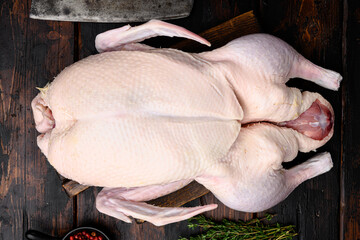 Fresh raw whole duck ready for cooking, on old dark  wooden table background, top view flat lay