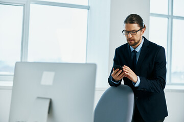 The man in a suit in the office gestures with his hands executive