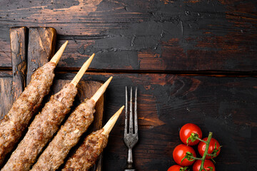 Shish kebab on a stick, from ground land mutton meat, on serving board, on old dark  wooden table...