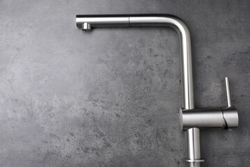 Modern pull out kitchen faucet on grey table, top view. Space for text