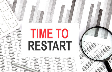 TIME TO RESTART text on document with pen,graph and magnifier,calculator