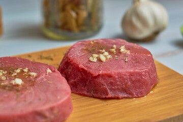 Close up of fresh raw tuna steaks on wooden board. Healthy food concept.