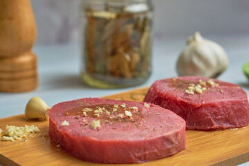 Close up of fresh raw tuna steaks on wooden board. Healthy food concept.