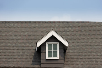 fake window on garret house and roof shingle with blue sky background. Asphalt Shingles or Bitumen Tiles.