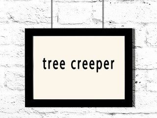 Black frame hanging on white brick wall with inscription tree creeper