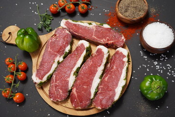 Raw meat beef steak on black top view.