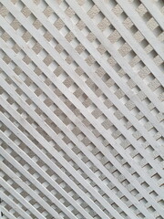 The white painted hardwood pieces are arranged in beautiful rhombuses. The battens are used to divide the space or decorate the interior of the building. decorative grid panels. 
