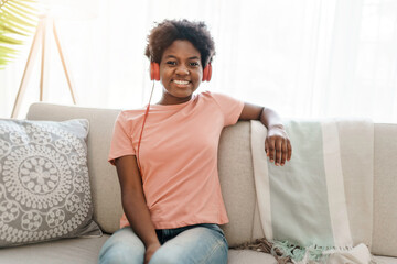 happy african american woman with headphones listening to music at home