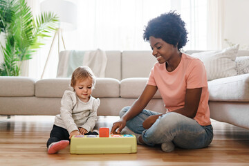 nursery babysitter with baby play with toys - obrazy, fototapety, plakaty