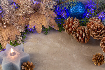 Fototapeta premium christmas composition in silver blue color, blue garland, spruce branches, candle on gray background, copy space