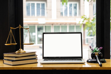 Fototapeta premium Laptop and judge's hammer and scales ah justice with notebook on lawyer's desk in legal concept office