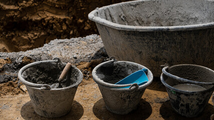 Fototapeta premium 4 cement buckets on the floor for a construction industry business idea.