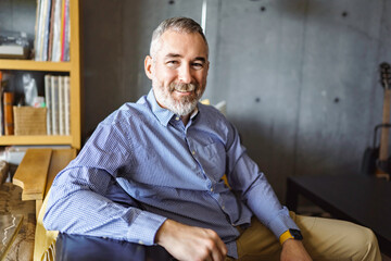 close portrait of Joyful mature man at home appartement with grey beard