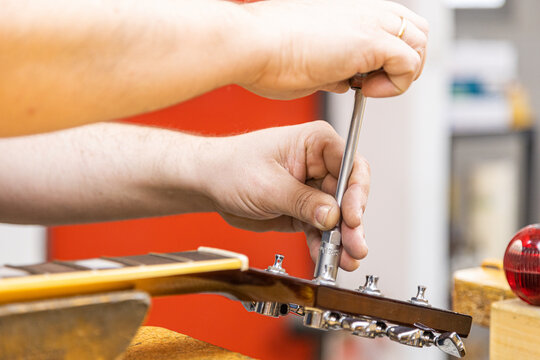 Master fixing guitar in professional workshop studio
