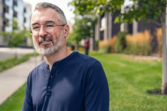 Mature Man Walking Outside In City Background