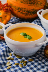 Homemade pumpkin soup with cream and basil
