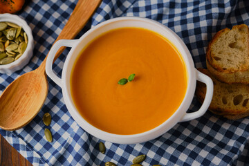 Homemade pumpkin soup with cream and basil