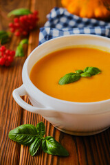 Homemade pumpkin soup with cream and basil