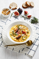 Pumpkin soup with feta, figs, pine nuts, top view