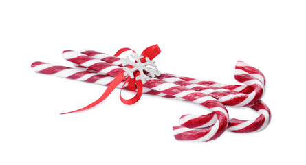 Sweet Christmas candy canes with red bow and snowflake on white background