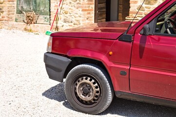 An old red car parked in the courtyard (Tuscany, Italy, Europe) - 461728550